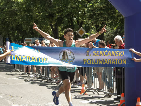 Győztes széttárt karral, teljes kétnyelvű szalaggal, szurkolókkal